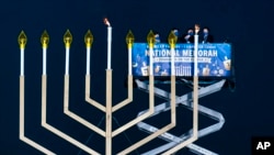 FILE - A U.S. government official joins rabbis lighting the National Hanukkah Menorah on The Ellipse, in Washington, Dec. 10, 2020.