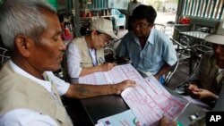 Myanmar census enumerators ask questions to a family member while collecting information in Sittwe, Rakhine State, western Myanmar, Monday, March 31, 2014. Enumerators fanned out across Myanmar on Sunday for a census that has been widely criticized for st