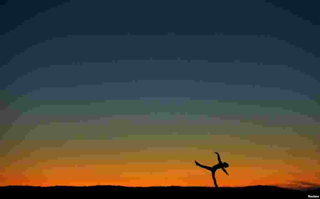 Former ballerina Luke Willis plays on a sand berm after sunset in Encinitas, California, USA, Jan. 12, 2016.