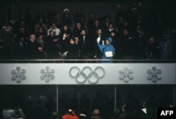 Putra Mahkota Akihito (kiri) dan Putri Michiko (kanan) melambaikan tangan saat upacara penutupan Olimpiade Musim Dingin di Sapporo, 13 Februari 1972. (Foto: AFP)