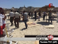 In this screen grab taken from video provided by Tunisia TV1, injured people are treated on a Tunisian beach at the resort town of Sousse, June 26, 2015.