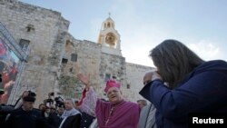 2014年12月24日，天主教耶路撒冷大主教特沃（Fouad Twal）抵达西岸城市伯利恒参加圣诞节庆祝时向欢迎人群挥手致意。