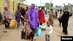 Somali families move out of their homes after they were broken into during the second day of skirmishes in the Eastleigh neighborhood of Kenya's capital Nairobi, Nov. 19, 2012. 
