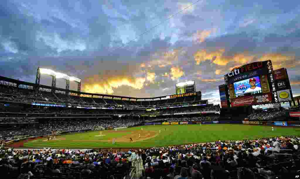 The sun sets over Citi Field during the fifth inning of a baseball game between the New York Mets and the St. Louis Cardinals in New York, June 11, 2013. 