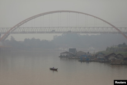 Seorang pria memancing saat kabut asap menutupi sungai Kahayan di Palangka Raya, Provinsi Kalimantan Tengah, 17 September 2019. (Foto: REUTERS/Willy Kurniawan)