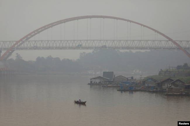 Seorang pria memancing saat kabut asap menutupi sungai Kahayan di Palangka Raya, Provinsi Kalimantan Tengah, 17 September 2019. (Foto: REUTERS/Willy Kurniawan)