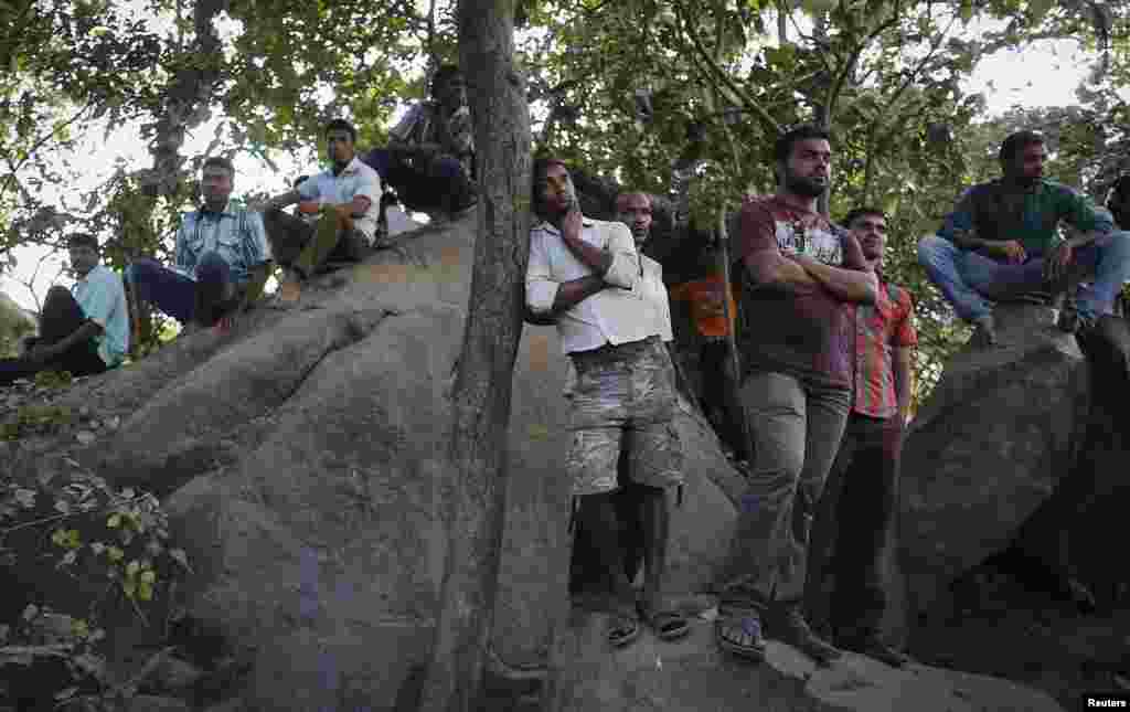 Para kerabat dari orang yang hilang menyaksikan operasi penyelamatan di lokasi gedung yang ambruk di Canacona, India (5/1). (Reuters/Danish Siddiqui)