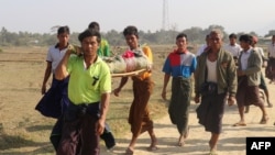 FILE - Residents carry the body of an ethnic Rakhine woman for burial in Rathedaung township, after fresh fighting in Rakhine state between the Myanmar military and the Arakan Army, an ethnic Rakhine force, Feb. 21, 2019.