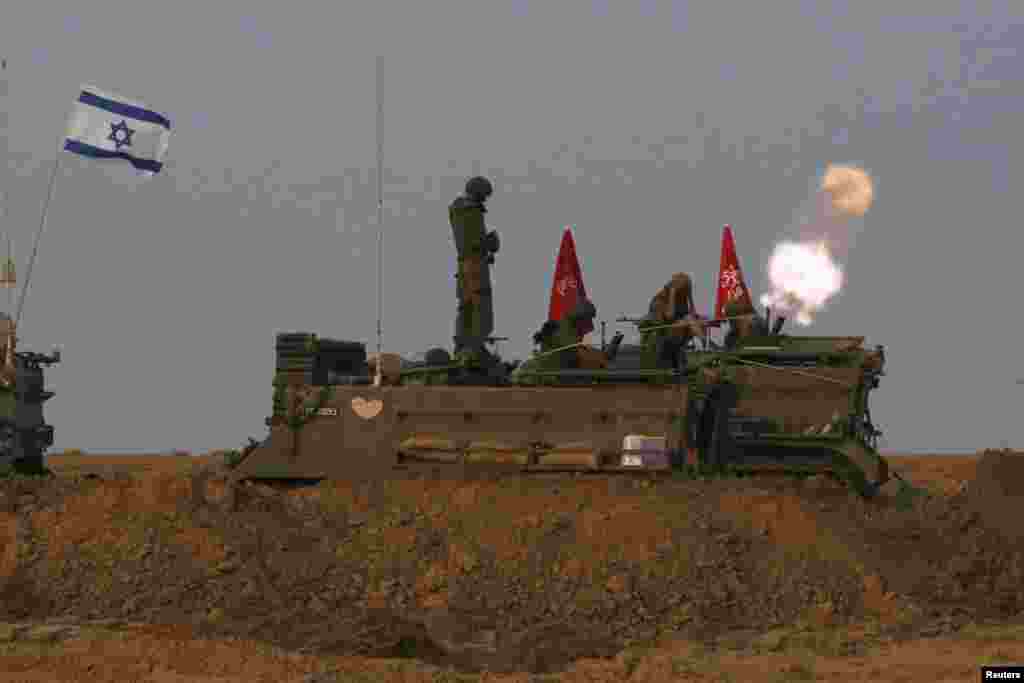 Israeli soldiers stand on an armored personnel carrier outside the central Gaza Strip as they fire mortar shell towards Gaza before a cease-fire was due, early Aug. 1, 2014.