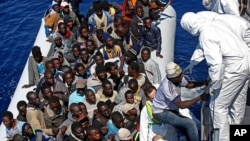지난 22일 지중해에서 이탈리아의 구조용 고무보트에 탄 난민들이 이탈리아 해안경비선으로 옮겨타고 있다. (자료사진)