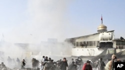People react seconds after a suicide blast targeting a Shi'ite Muslim gathering in Kabul, December 6, 2011.
