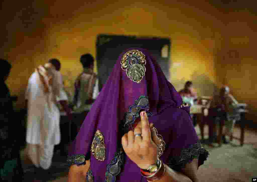 A woman displays the indelible ink mark on her finger after casting her vote at a polling station in Kunwarpur village in the northern Indian state of Uttar Pradesh, India, May 12, 2014.