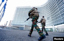 Belgian soldiers patrol outside the European Commission headquarters as police searched the area during a continued high level of security following the recent deadly Paris attacks, in Brussels, Belgium, Nov. 23, 2015.
