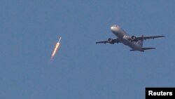 A recycled SpaceX Falcon 9 rocket soars toward space above a Virgin Airlines passenger jet, which had just departed Orlando International Airport, in Orlando, Florida, March 30, 2017. The launch marked the first time ever that a rocket was reused for spaceflight.