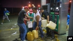 FILE - Residents pilfer gasoline and diesel from a gas station following protests against an increase in fuel prices in Allende, southern Veracuz state, Mexico, Jan. 3, 2017. 