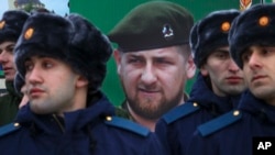 Čečenski vojnici ispred postera sa likom Ramzana Kadirova