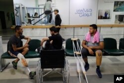 Syrian soldiers who lost their legs while fighting in Syria's war, attend a physical therapy session at the Ahmad Hamish Martyr hospital, in Damascus, Oct. 7, 2018.