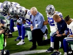 FILE - The Dallas Cowboys, led by owner Jerry Jones, center, take a knee before the national anthem at an NFL football game against the Arizona Cardinals, in Glendale, Ariz., Sept. 25, 2017.