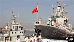 中國海軍官兵登上青島號導彈驅逐艦(右)去參加中美海軍聯合演習