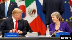 FILE - U.S. President Donald Trump and Britain's Prime Minister Theresa May attend the G20 leaders summit in Buenos Aires, Argentina, Nov. 30, 2018.