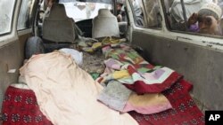 An Afghan boy peeks into a bus carrying the body of a person who was allegedly killed by a U.S. service member in Panjwai, Kandahar province south of Kabul, Afghanistan, Sunday, March 11, 2012. Afghan President Hamid Karzai says a U.S. service member has 