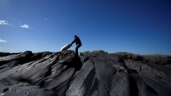 Patrick Darcy, a seaweed harvester, heaves a sack full of harvested Dillisk seaweed (palmaria palmata) to carry on his back in the County Clare village of Quilty, Ireland, April 13, 2021. (REUTERS/Clodagh Kilcoyne)