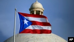 FILE - The Puerto Rican flag flies in front of the U.S. territory's Capitol in San Juan, Puerto Rico, July 29, 2015.