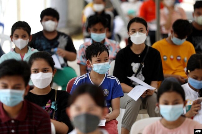 Para remaja menunggu untuk menerima vaksin Sinovac di sebuah pusat kesehatan di Phnom Penh pada 1 Agustus 2021, saat Kamboja mulai memvaksinasi remaja berusia antara 12 hingga 17 tahun. (Foto: AFP/Pring Samrang)