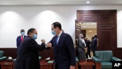 PM Sudan Abdullah Hamdok (kiri) menyalami Menteri Keuangan AS Steven Mnuchin (kanan) dengan saat tiba di Gedung Kabinet di Khartoum, Sudan, 6 Januari 2021.