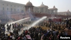 Polisi berupaya mengendalikan massa di depan istana kepresidenan di New Delhi dengan mempergunakan gas air mata dan meriam air (22/12). (Reuters/Adnan Abidi) 