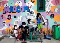Anak-anak mengenakan masker duduk di atas jungkat-jungkit di tengah wabah COVID-19 di Jakarta, 7 September 2021. (REUTERS/Ajeng Dinar Ulfiana)