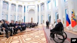 Sir Philip Craven, président du comité paralympique parle avec le président Vladimir Poutine, le 24 mars 2014.