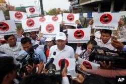 Ath Thun, center, president of the Coalition of Cambodian Apparel Workers' Democratic Union, delivers a speech during a protest rally at a blocked street near National Assembly, in Phnom Penh, Cambodia, Monday, April 4, 2016.