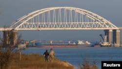 A Russian cargo ship is seen beneath a bridge connecting the Russian mainland with the Crimean Peninsula after three Ukrainian navy vessels were stopped by Russia from entering the Sea of Azov via the Kerch Strait in the Black Sea, Crimea Nov. 25, 2018.