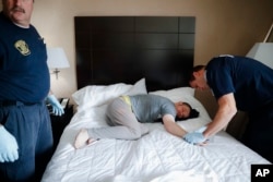 FILE - Cincinnati police officers, firefighters and medics respond to a possible overdose report at a hotel in downtown Cincinnati.