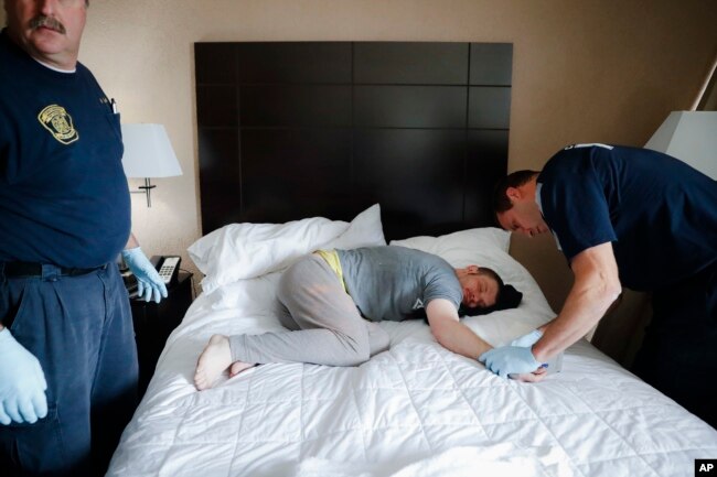 FILE - Cincinnati police officers, firefighters and medics respond to a possible overdose report at a hotel in downtown Cincinnati.