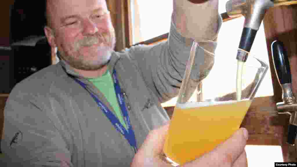 Dirk van Tonder pulls a pint of his own Orange Blossom Weissbier, a German wheat beer, for a customer. (Photo Credit: Darren Taylor)