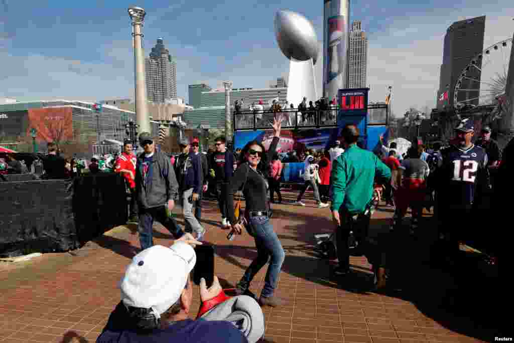 A woman poses near a giant replica of the Vince Lombardi Trophy during an NFL fan celebration in Centennial Park outside Mercedes Benz Stadium ahead of Super Bowl LIII in Atlanta, Georgia, Feb. 2, 2019.