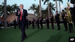 FILE - President Donald Trump listens to the Palm Beach Central High School Band as they play at his arrival at Trump International Golf Club in West Palm Beach, Florida, Feb. 5, 2017.
