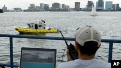 Computer scientist Mohamed Saad Ibn Seddik, of Sea Machines Robotics, uses a laptop to guide a boat outfitted with sensors and self-navigating software and capable of autonomous navigation in Boston Harbor, Aug. 15, 2017. The boat still needs human oversight, but some of the world's biggest maritime firms have committed to designing ships that won't need any captains or crews - at least not on board. 