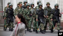 Paramilitary policemen with shields and batons patrol near the People's Square in Urumqi, China's northwestern region of Xinjiang, May 23, 2014.