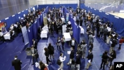 Students walk among recruiting booths during a career job fair at American University in Washington, March 28, 2012. 