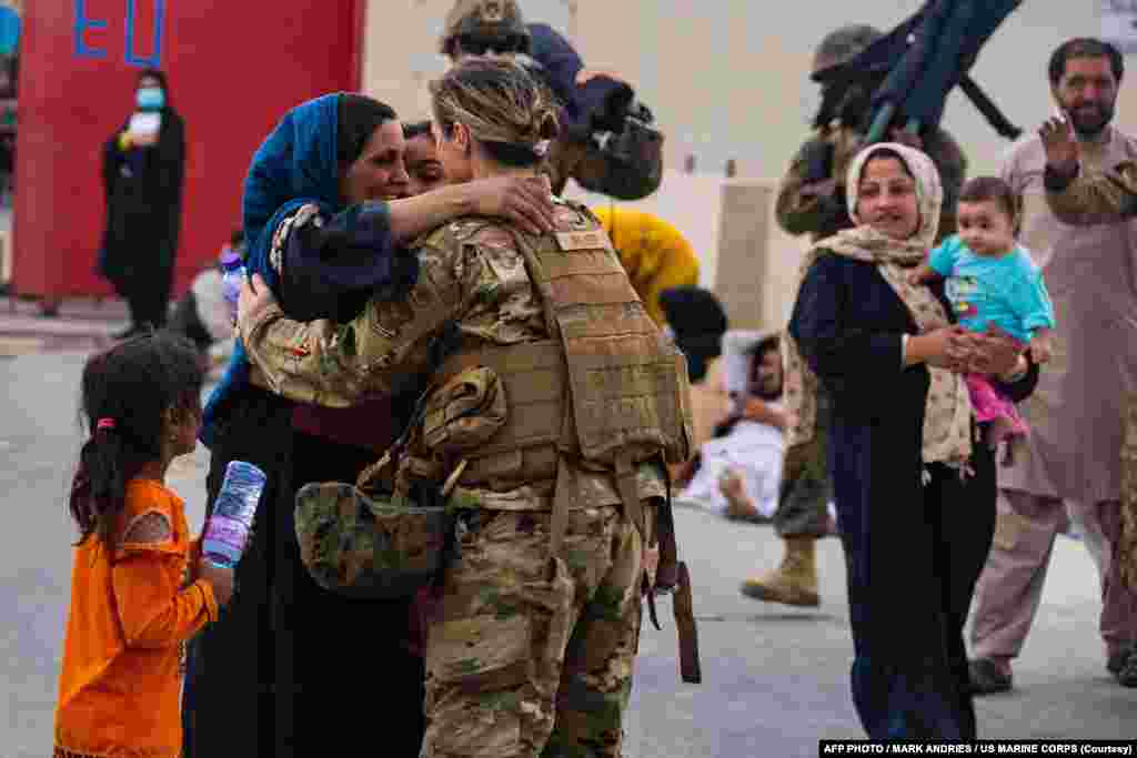 افغان خاتون امریکی میرین افسر کے ساتھ گلے مل کر خوشی کا اظہار کر رہی ہیں۔