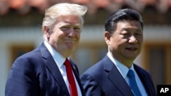 President Donald Trump and Chinese President Xi Jinping walk together after their meetings at Mar-a-Lago, April 7, 2017, in Palm Beach, Fla.