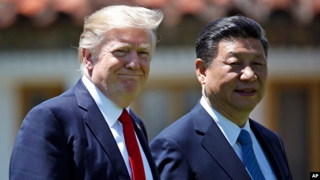 President Donald Trump and Chinese President Xi Jinping walk together after their meetings at Mar-a-Lago, April 7, 2017, in Palm Beach, Fla.