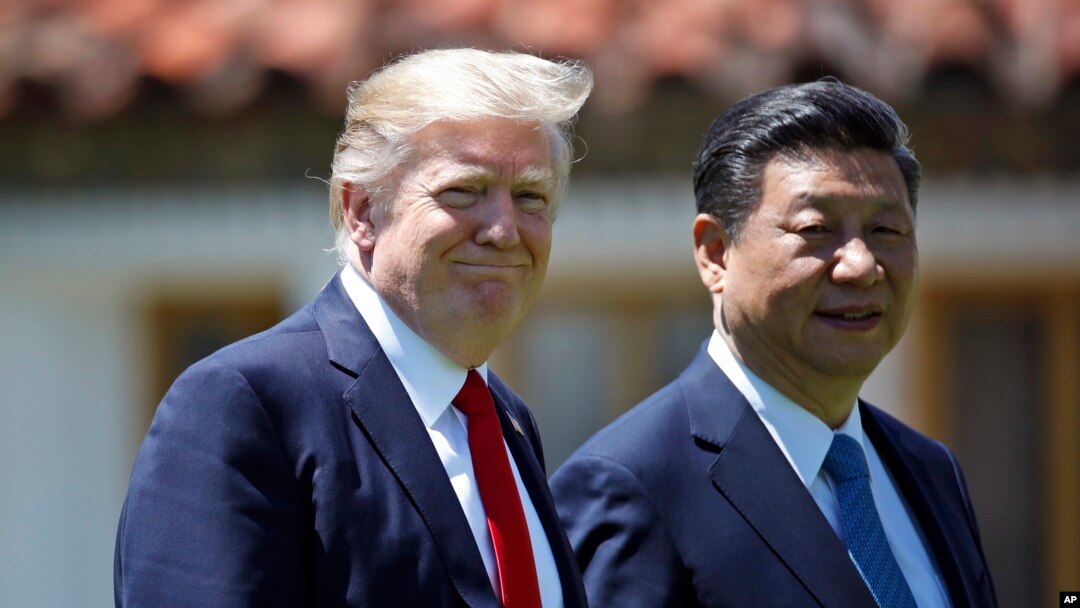 FILE - President Donald Trump and Chinese President Xi Jinping walk together after their meetings at Mar-a-Lago, April 7, 2017, in Palm Beach, Florida, during their first bilateral meeting.