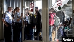 Pengungsi tiba di Rodby di Denmark, sementara polisi Denmark membawa mereka ke sebuah gedung di pelabuhan, 8 September 2015.