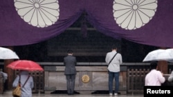 FILE - Visitors pray at the Yasukuni Shrine in Tokyo, Japan, Oct. 17, 2016.