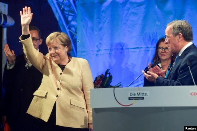 Kanselir Jerman Angela Merkel melambai di samping pemimpin Uni Demokratik Kristen (CDU) dan kandidat teratas untuk kanselir Armin Laschet selama rapat umum pemilihannya di Stralsund, Jerman, 21 September 2021. (Foto: Reuters)