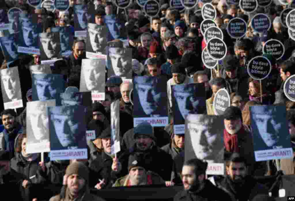 Hundreds of people hold placards that read 'This case won't end this way' and showing a portrait of Hrant Dink, outside a courthouse in Istanbul, Turkey, Tuesday, Jan. 17, 2012. A prosecutor is demanding life imprisonment for seven men accused of involve